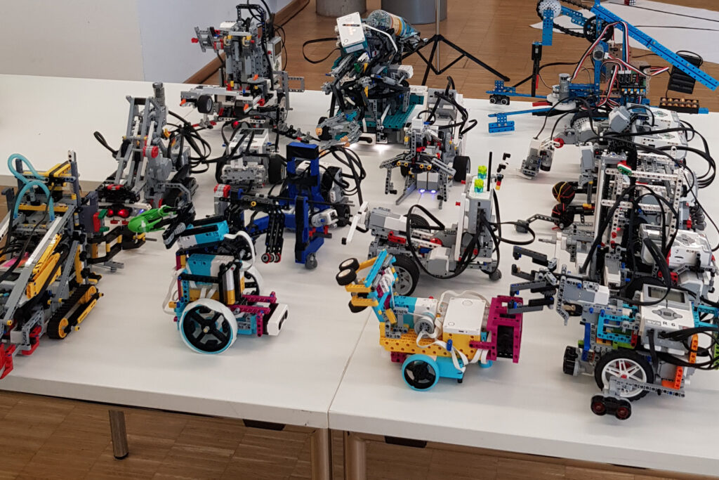 Verschiedene selbst gebaute Robotermodelle auf einem Tisch bei der Robocom 2024