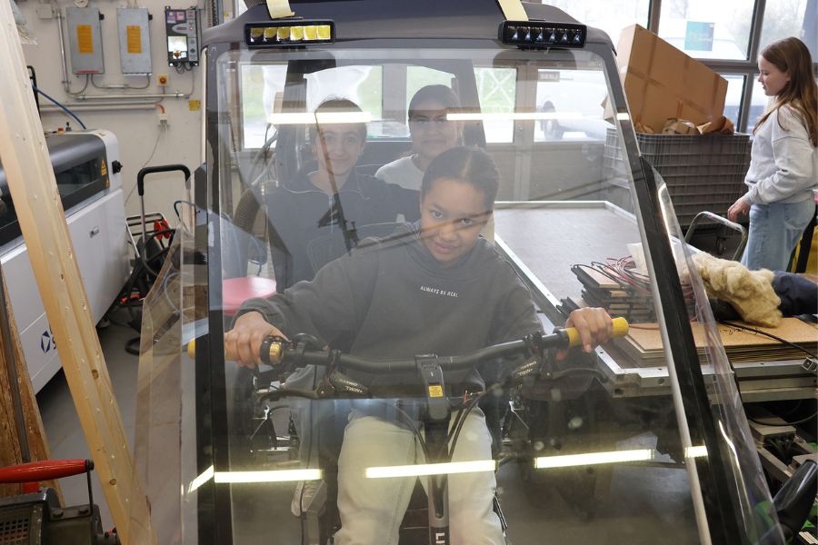 Drei Schülerinnen sitzen im Fahrradauto "fair.be" im Makerspace der Westfälischen Hochschule
