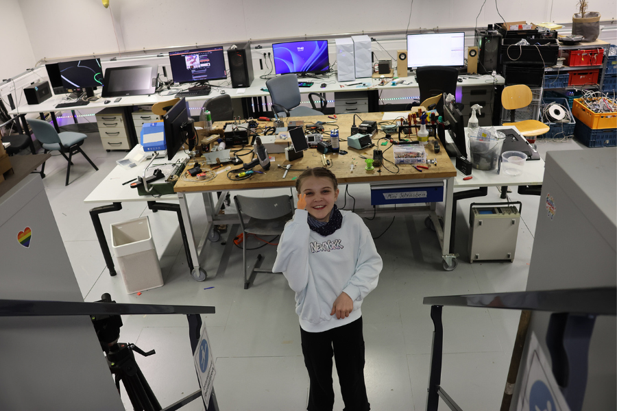 Schülerin steht im Makerspace und schaut in die Kamera