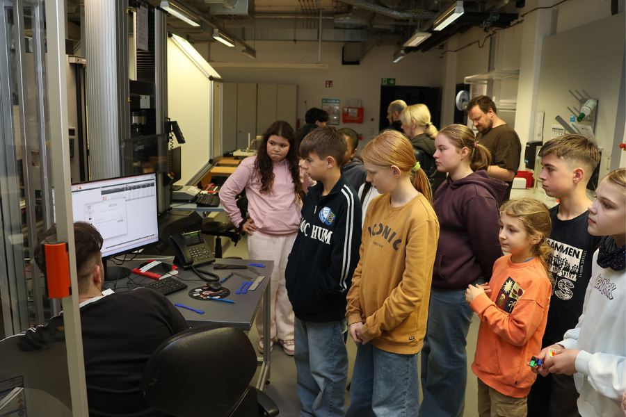 Schüler:innen schauen sich Ergebnisse einer Werkstoffprüfung auf dem Computer an